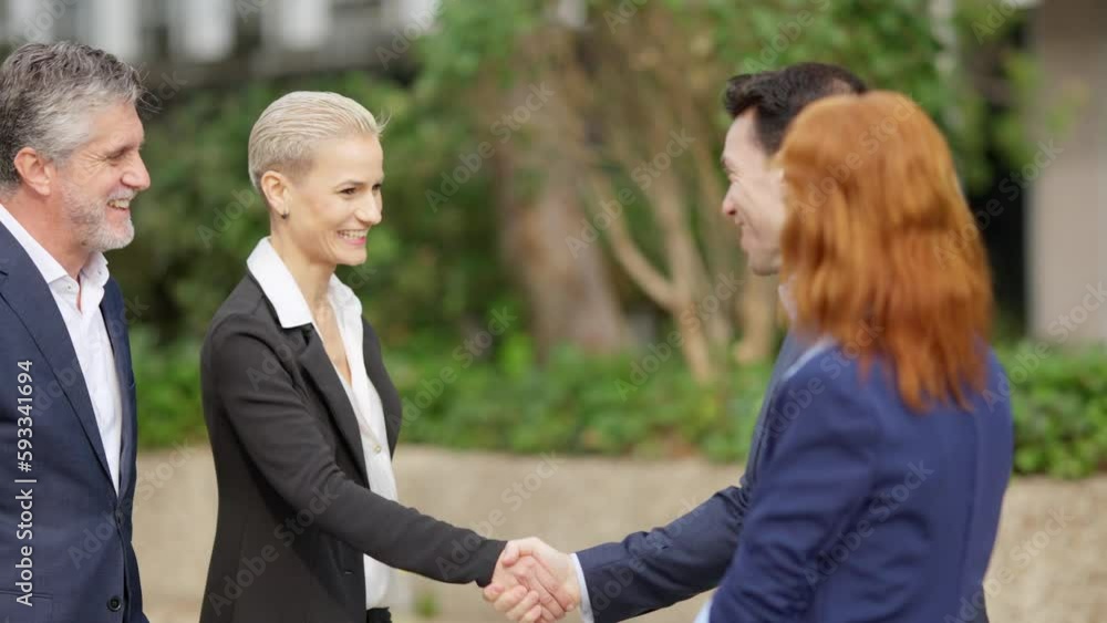 Businesswoman shaking hands with a colleague outdoors Businesswoman shaking hands with a colleague outdoors