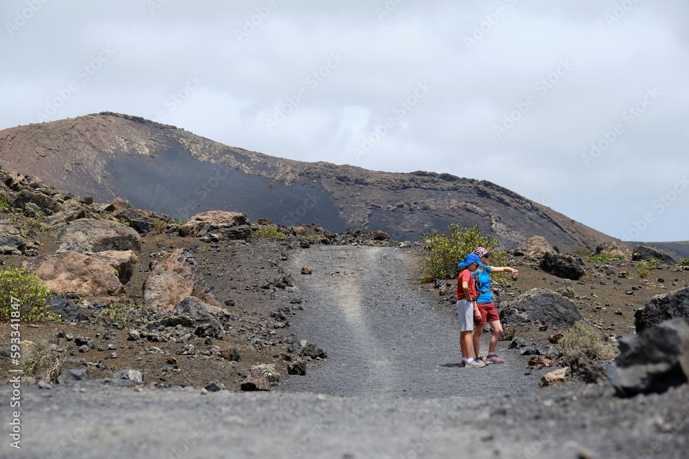 Mother and son trekking in the volcanoes of Lanzarote, Canary Islands.