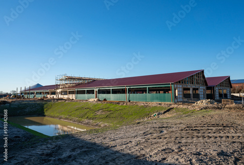 Moderner Stallbau - Neubau einer Tierwohl - Schweinemastanlage mit angeschlossener Biogasanlage und Reckenrückhaltebecken. Landwirtschaftisches Symbolfoto.