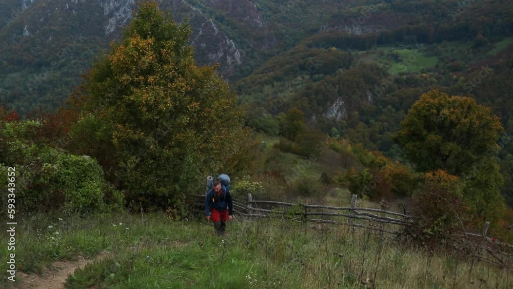 Male hiker walking on a trail in Cernei mountains, Romania Male hiker walking on a trail in Cernei mountains, Romania