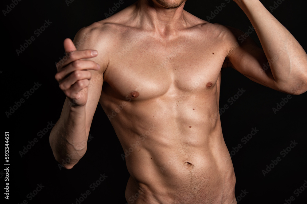 Adult attractive man with a beautiful body posing in the studio. Black background. Adult attractive man with a beautiful body posing in the studio. Black background.