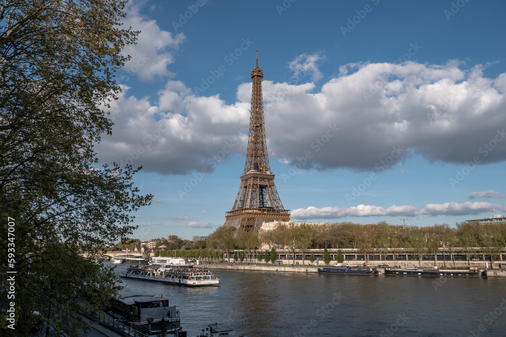 Eiffel tower with a barge passing by on a sunny day