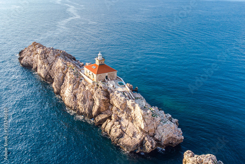 Photo of a lonely rocky island with lighthouse in Croatia - island Grebeni