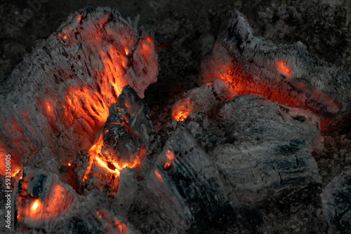 Wood fire. Burning embers with bright color. Wood fire with hot embers and ashes. Background dedicated to the barbecue and the flames in the fire similar to lava and burning coal in a fireplace.