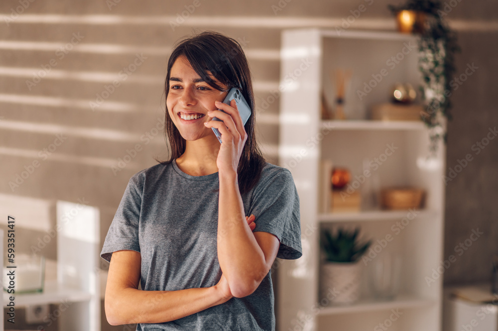 Beautiful young woman talking on her cell phone while enjoying and laughing. Beautiful young woman talking on her cell phone while enjoying and laughing.