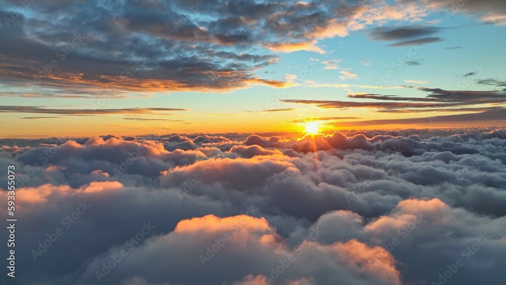 Sun goes into the clouds. Epic sunset in the sky, aerial shot. Flying above the clouds illuminated by the evening sun - obrazy, fototapety, plakaty 