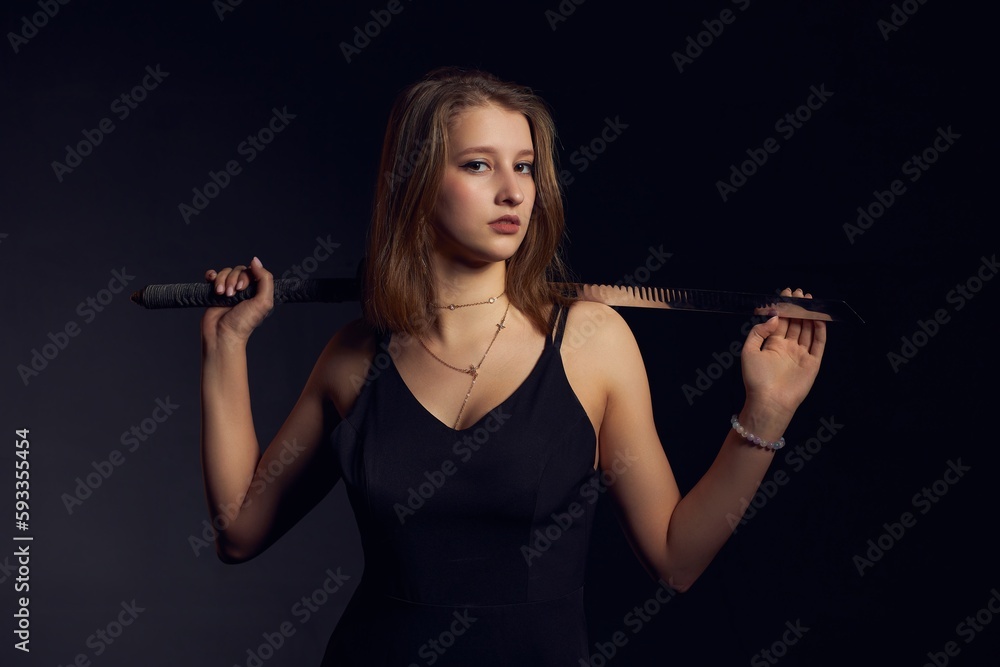 Fototapeta premium Young female with katana on black background