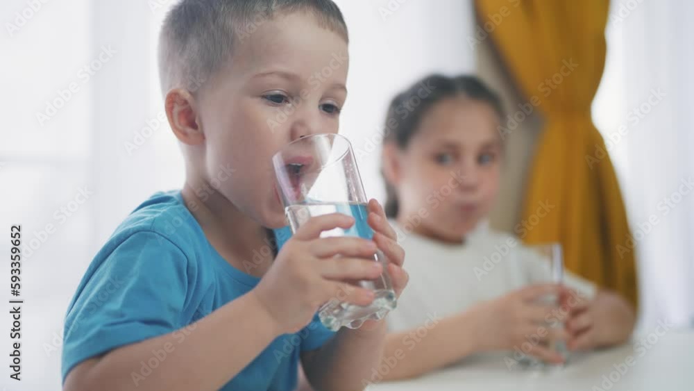 Vidéo Stock Children indoors drinking glassware water. Crisis clean a