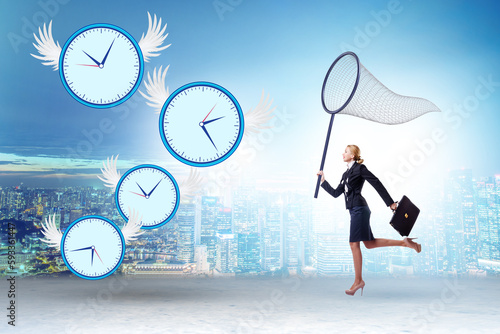 Deadline concept with businesswoman catching clocks photo