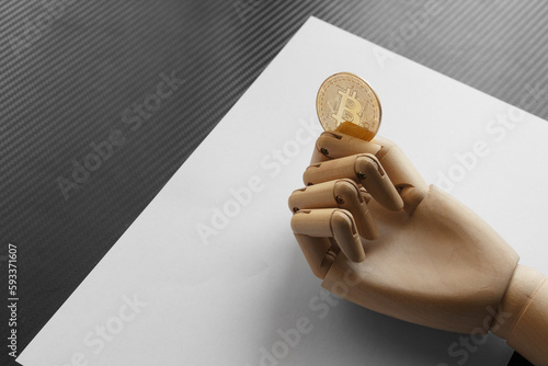 Artificial hand holding one bitcoin on white paper background. Virtual money concept and Financial growth concept. Trading Mining of bitcoins.
