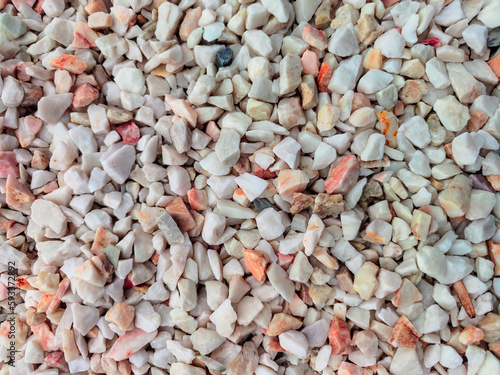 Light decorative stones for the garden in shades of beige, pink and brown. Stone background.