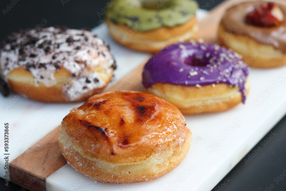 Assorted gourmet and colorful donuts served on a board