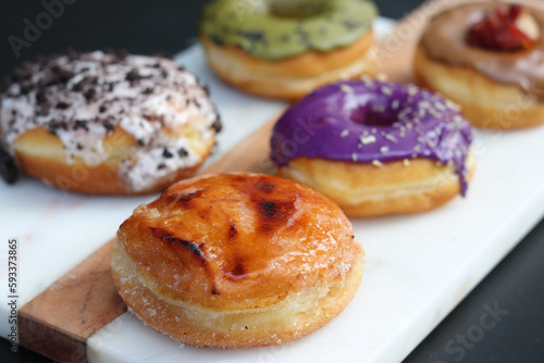 Assorted gourmet and colorful donuts served on a board