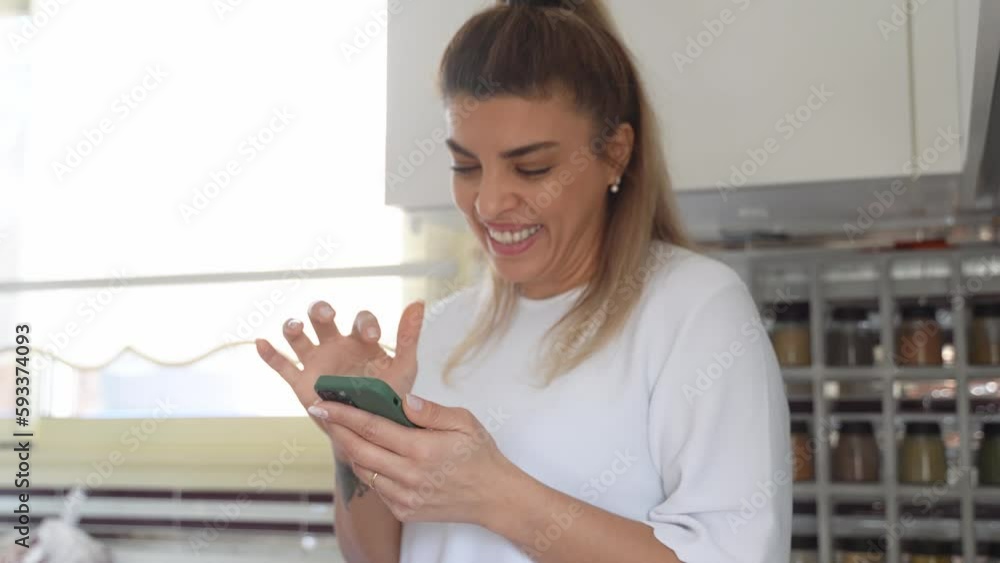 Woman using smartphone in Kitchen At Home. Housewife online shopping, looking for receipt, surfing the Internet, order food delivery from grocery shop or cafe restaurant, paying household bill Woman using smartphone in Kitchen At Home. Housewife online shopping, looking for receipt, surfing the Internet, order food delivery from grocery shop or cafe restaurant, paying household bill