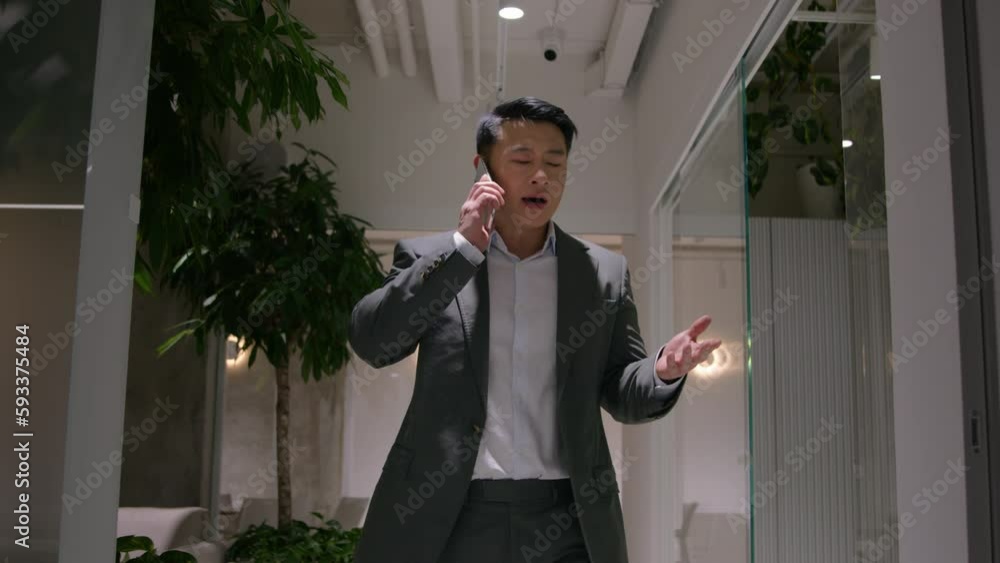 Asian korean mature man angry talking mobile phone walk in corporate office business call cellphone nervous mad chinese professional businessman talk smartphone irritated speak shout quarrel conflict Asian korean mature man angry talking mobile phone walk in corporate office business call cellphone nervous mad chinese professional businessman talk smartphone irritated speak shout quarrel conflict