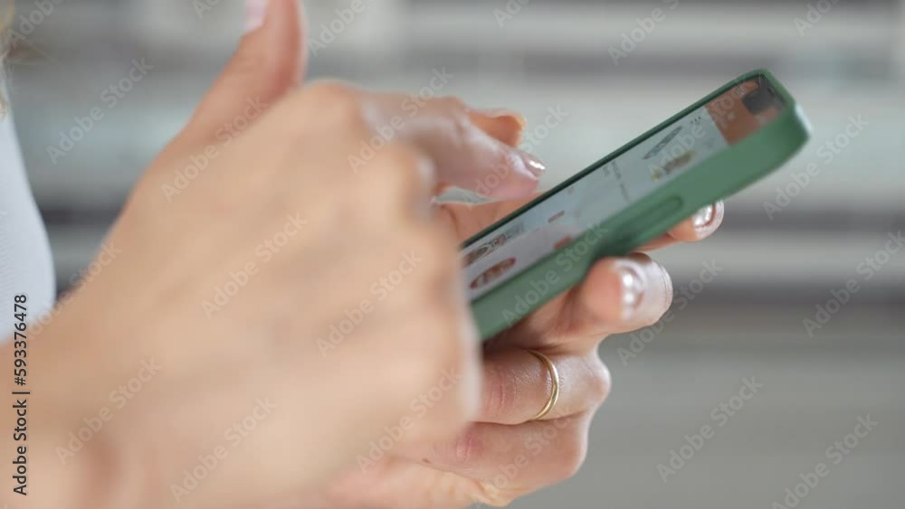Close-up Woman hand using smartphone in Kitchen At Home. Housewife online shopping, looking for receipt, surfing the Internet, order food delivery from grocery shop or cafe restaurant, paying Close-up Woman hand using smartphone in Kitchen At Home. Housewife online shopping, looking for receipt, surfing the Internet, order food delivery from grocery shop or cafe restaurant, paying