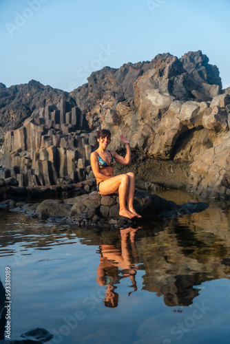 Sunset on El Hierro Island. Canary Islands, a tourist woman bathing in the natural pool of Charco Azul © unai