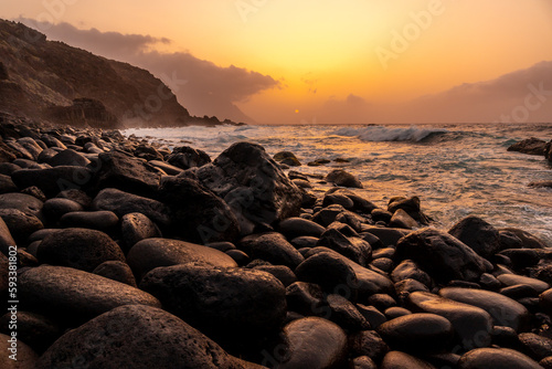 El Hierro Island. Canary Islands, landscape of stones next to Charco azul in the orange sunset, photo at sea level