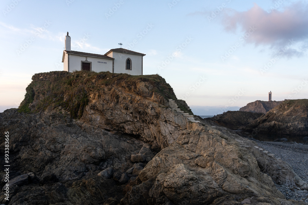 Virxe do Porto (Valdoviño) hermitage and Punta Frouxeira lighthouse with the cliffs in the Rias Altas touristic area of Galicia at sunset, Meiras, Spain.
