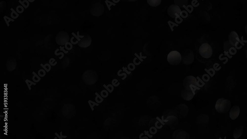 Silver Metallic Bokeh Overflow On Black Background. Motion of defocused circles. Abstract glow bokeh lights moving background. Can be used as background, overflow or transition on footages. 4K.