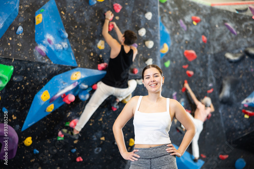 Young female climber getting ready to climb wall in gym