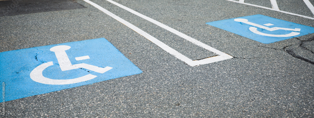 The blue handicap sign on the street is a universal symbol for accessibility and mobility aid for individuals with disabilities, representing equal opportunities and inclusion - obrazy, fototapety, plakaty 