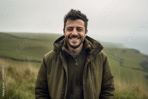 Portrait of a happy young man standing outdoors in the countryside.