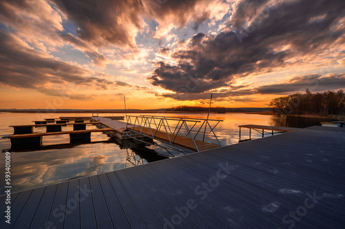 Colorful sunset with dramatic sky over an empty jetty by the water