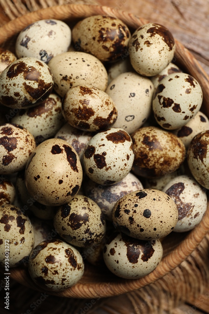 Wooden bowl with quail eggs on table, top view Wooden bowl with quail eggs on table, top view