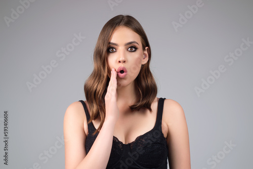Young surprised woman in t-shirt shouting wow, gray studio background. Shock content. Surprised woman raised eyebrows with surprised face. Young woman shocked with surprise and amazed expression.