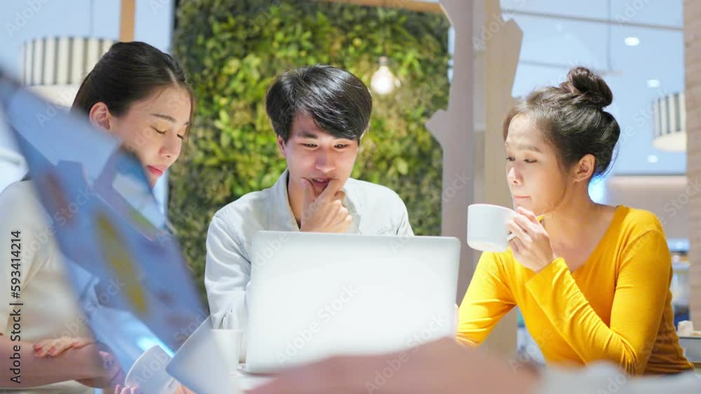 Group of Asian friends talking and using laptop computer in restaurant. Group of Asian friends talking and using laptop computer in restaurant.
