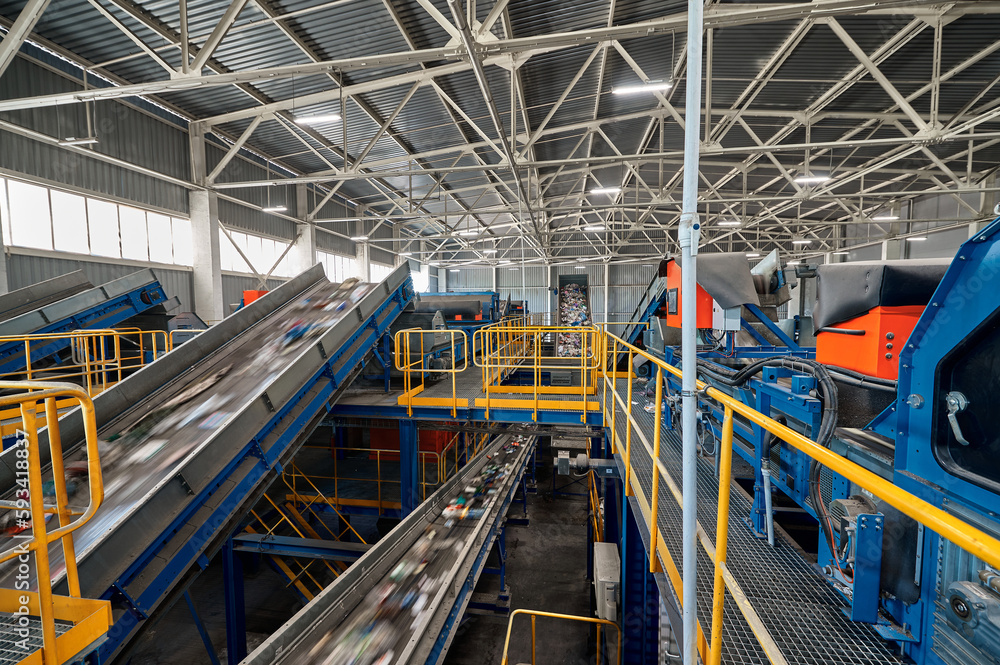 Conveyors carry trash and empty platforms at recycling plant