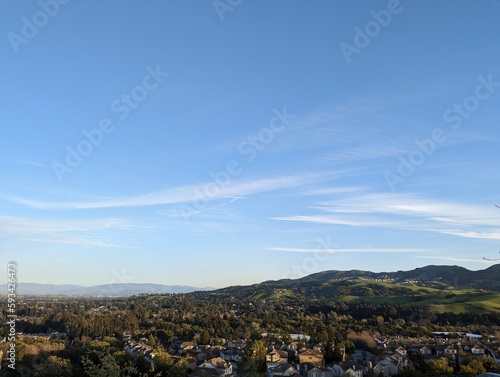 city of east San Francisco bay, San Ramon landscape with mountains and clouds, green hills visible in the foreground; San Francisco Bay Area, California 