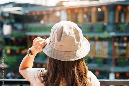 woman traveler visiting in Taiwan  Tourist with hat and backpack sightseeing in Jiufen Old Street village with Tea House background. landmark and popular attractions near Taipei city. Travel concept