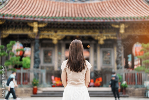 woman traveler visiting in Taiwan, Tourist with hat sightseeing in Longshan Temple, Chinese folk religious temple in Wanhua District, Taipei City. landmark and popular. Travel and Vacation concept