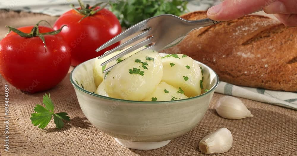 boiled potatoes prick with a fork in a bowl. farm products on the table. simple country food. potato dish with tomatoes and bread on burlap. natural food on a sunny day. boiled potatoes prick with a fork in a bowl. farm products on the table. simple country food. potato dish with tomatoes and bread on burlap. natural food on a sunny day.