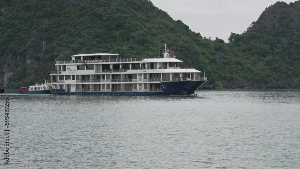Cruise Ships At Ha Long Bay Tour sailing By Karst Rock Mountains In Vietnam. Slow Motion Cruise Ships At Ha Long Bay Tour sailing By Karst Rock Mountains In Vietnam. Slow Motion