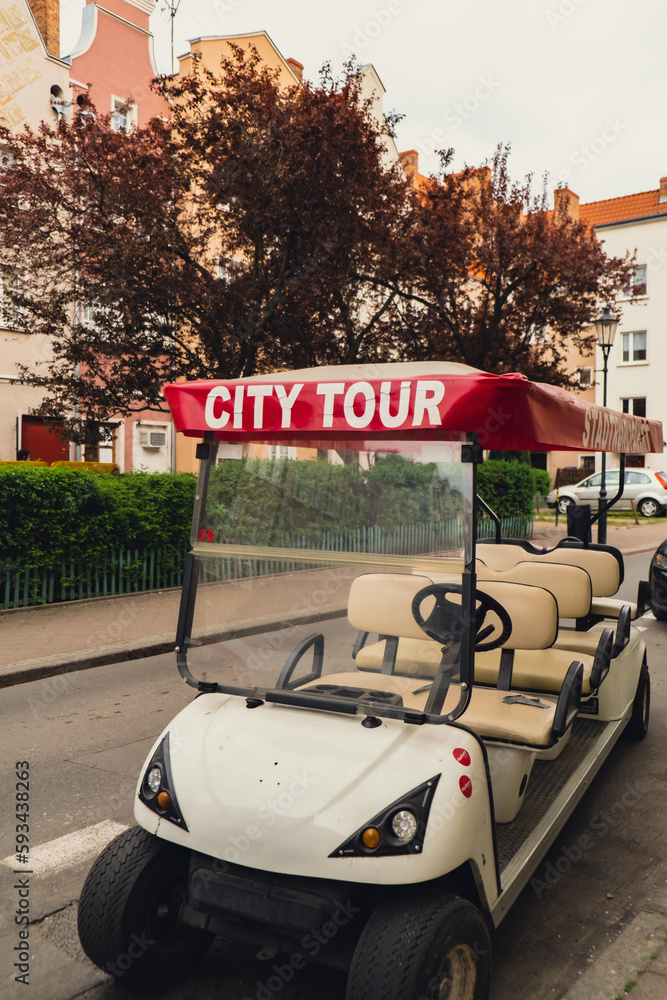 Red City tour car in the old city with text sign of Sightseeing city tour. Guided tour in Gdansk by car. Tourist attraction travel destination