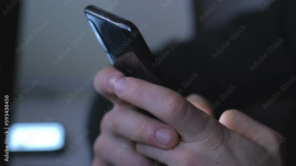 4k Young businessman at home sitting on a table reading phone message or downloading an app for his mobile phone. 4k Young businessman at home sitting on a table reading phone message or downloading an app for his mobile phone.