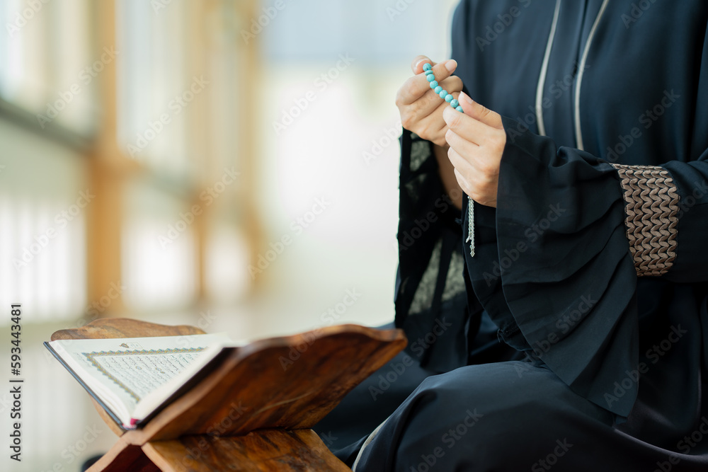 Fototapeta premium The image of an Asian Muslim woman in the Islamic religion in hijab in cream and black color. She was praying in a beautiful mosque out of respect for God.