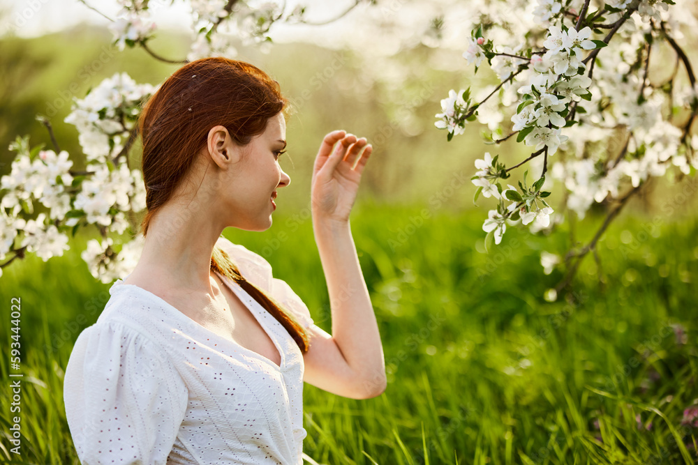 portrait of a beautiful woman looking at the flowers of an apple tree portrait of a beautiful woman looking at the flowers of an apple tree