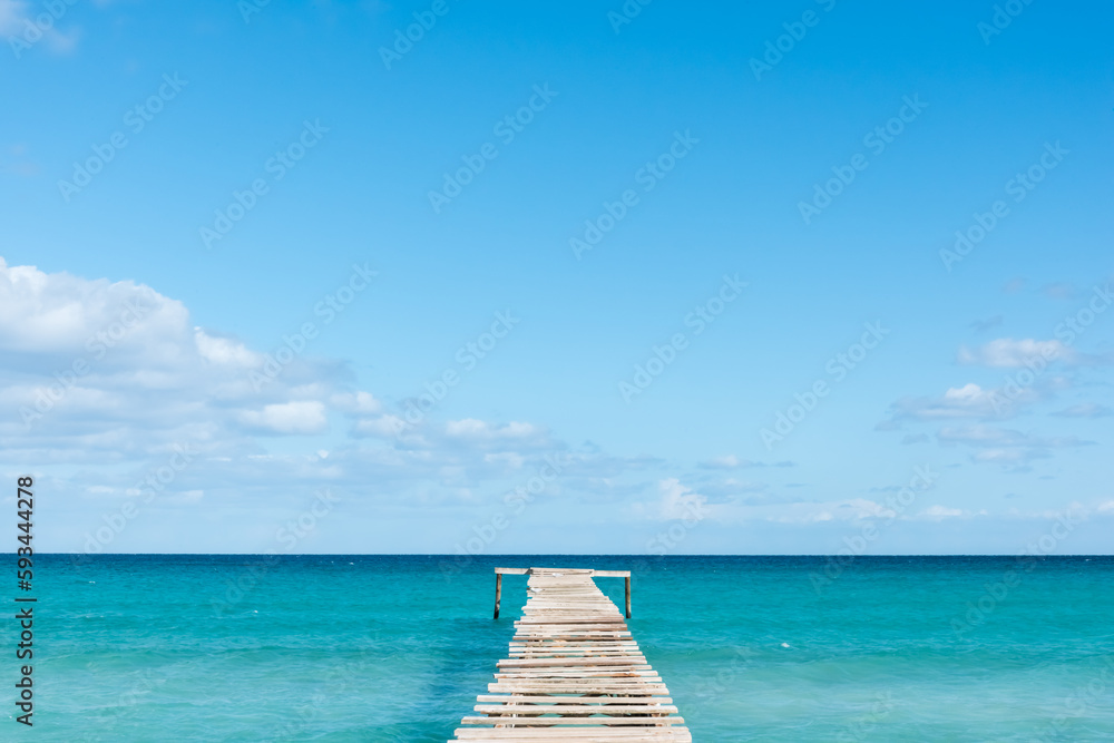 A footbridge that leads to the turquoise sea water