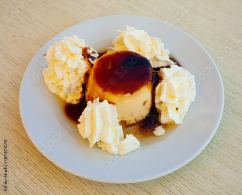 Image of tasty dessert cream flan served with butter cream at plate