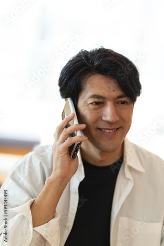 リビングで電話をする日本人男性