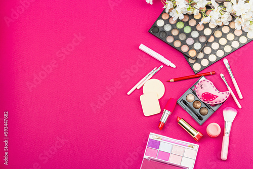 Make up set with colorful eyeshadow palettes, brushes, sponges and flowers. Viva magenta background