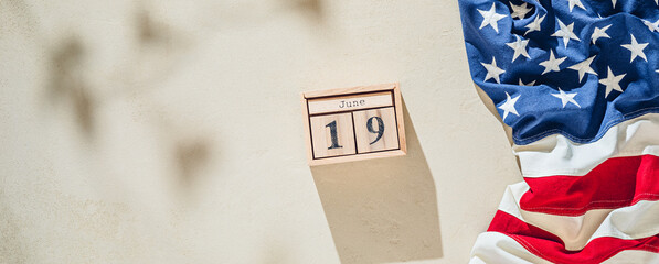Juneteenth background with American flag and wooden calendar. June 19 Federal holiday background