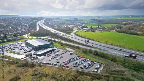 Aerial drone cinematic video footage of the M1 Motorway near the city of Wakefield, West Yorkshire, UK. Showing the busy motorway full of traffic and commercial buildings. photo