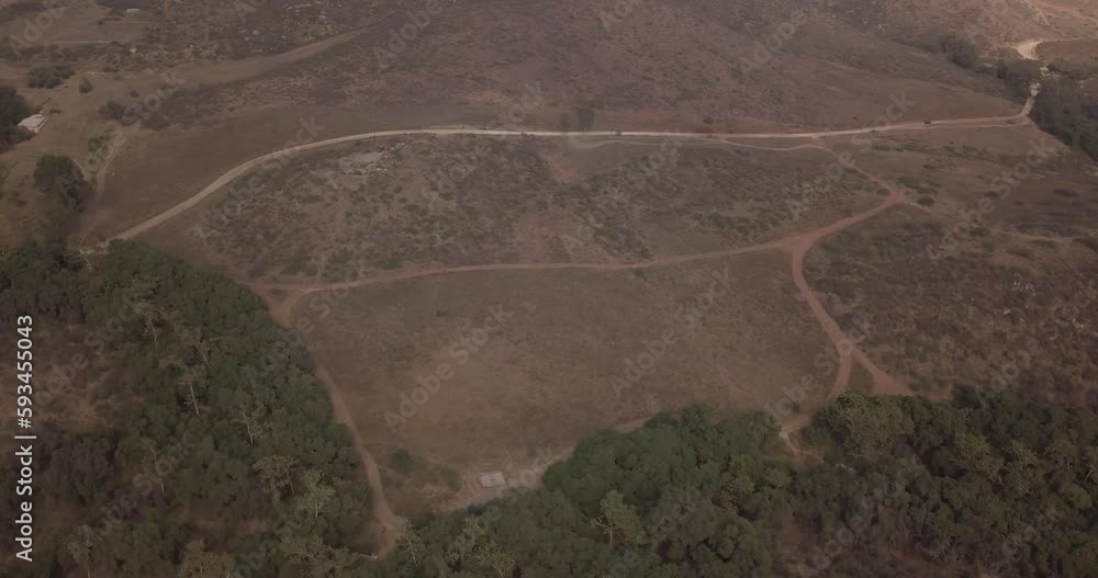 View from a drone flying in circles showing a mountain with two roads close to a forest in mexico View from a drone flying in circles showing a mountain with two roads close to a forest in mexico