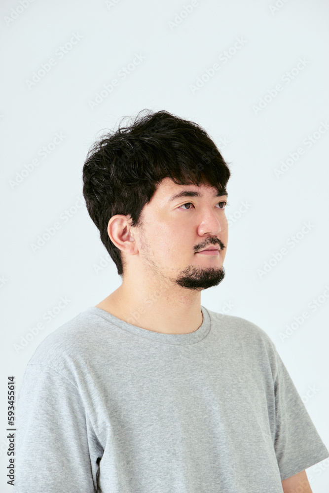 Obraz premium 白背景で右側を向いた30代の1人の髭を生やした日本人男性の人物の上半身