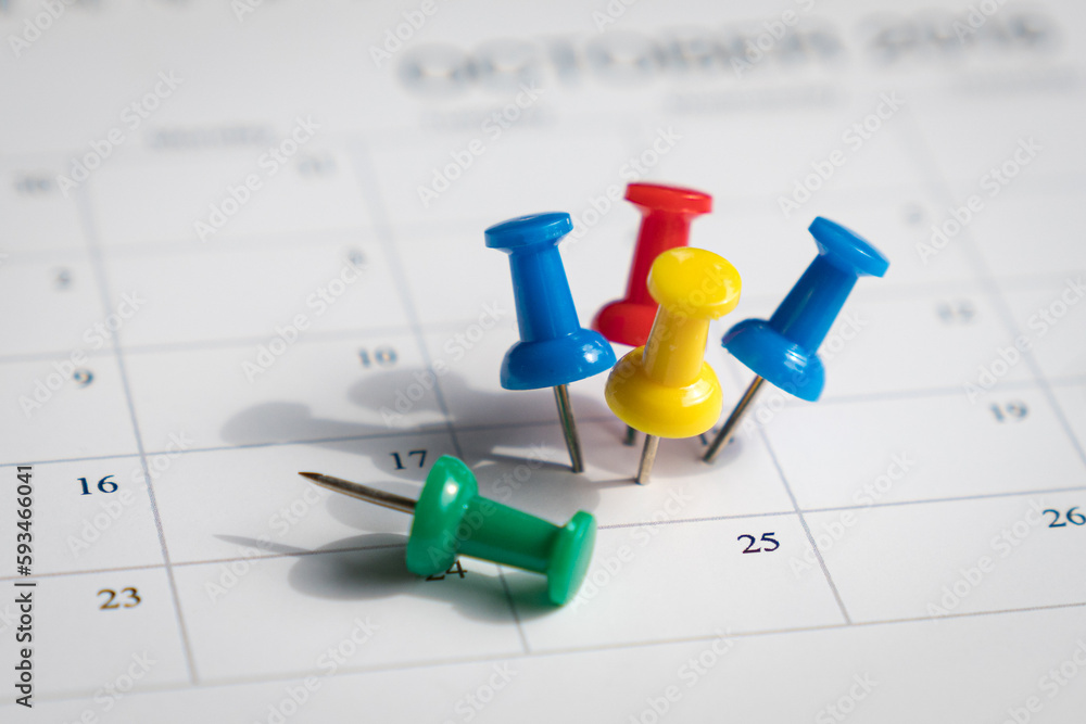 Multiple pins on one date on a calendar. Busy and fully booked schedule concept. Multiple pins on one date on a calendar. Busy and fully booked schedule concept.